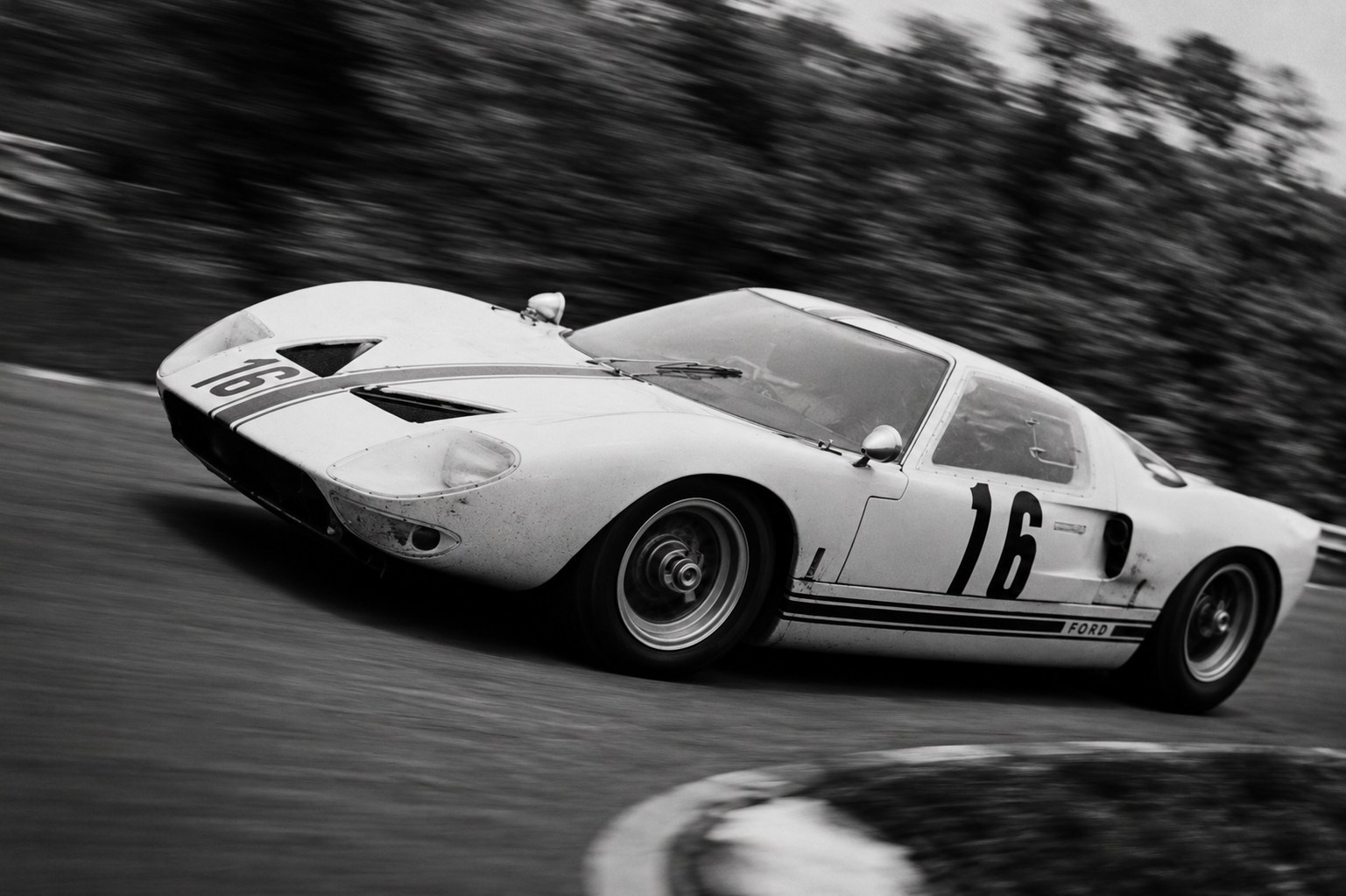 Ford GT40 mit Startnummer 16 in schneller Kurvenfahrt, Schwarzweiß